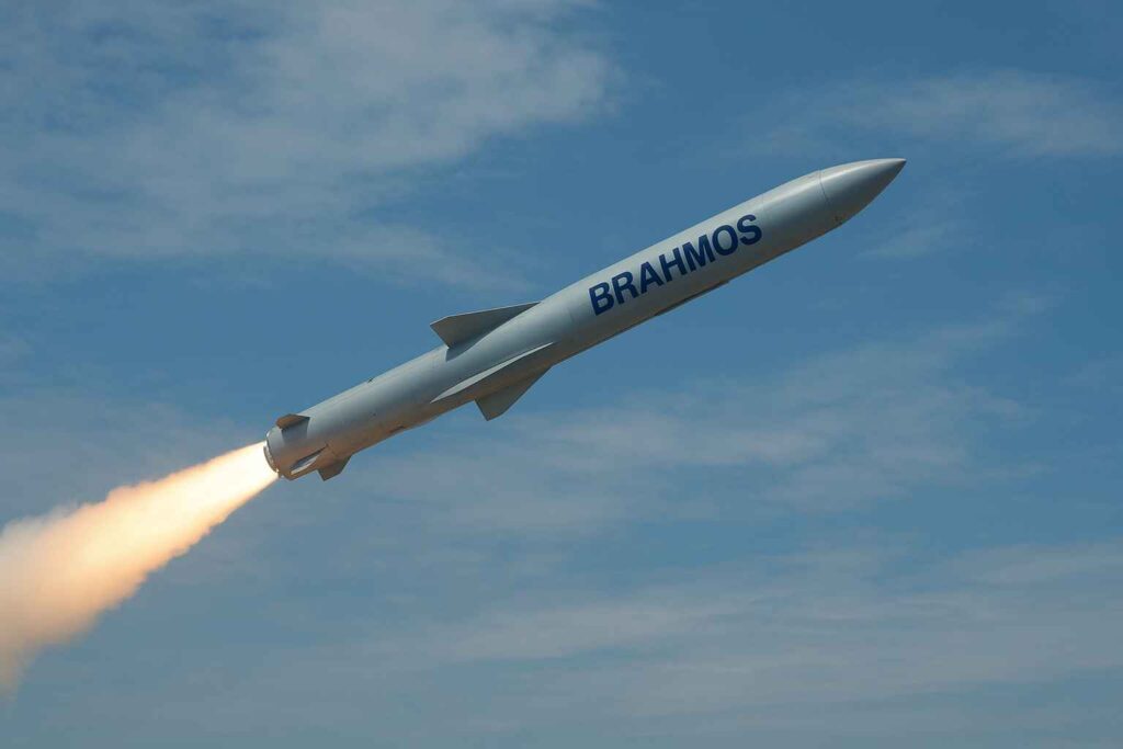 BrahMos missile hawa mein udti hui, Future Conflicts by 2030 ke sandarbh mein advanced military capabilities dikhate hue.