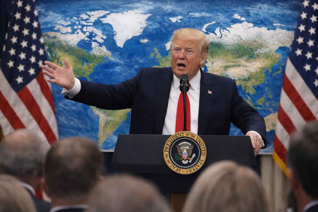 AI-generated image of Donald Trump giving a public speech with a world map, pointing towards Greenland